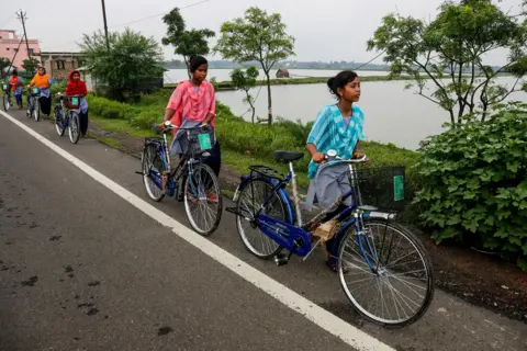 AP Village girls walk with bicycles they received from their school under a government scheme in Malancha, South 24 Pargana district, India, 