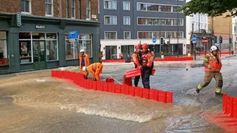 LONDON FIRE BRIGADE London Fire Brigade crews using flood barriers to divert water caused by a burst  water main in Pentonville Road