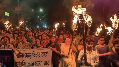 AFP Medical professionals, activists and citizens of Siliguri chant as they take part in a protest march named 'The Night is also ours' to condemn the rape and murder of a young medic, in Siliguri on 14 August, 2024