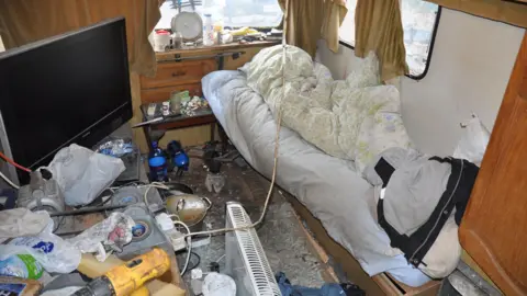 Lincolnshire Police Interior of caravan strewn with old bedding, dirty cooking utensils and electrical equipment