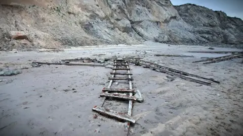 Gemma Clarke Five sections of railway track on the beach at Trimingham