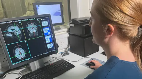 BBC Researcher looking at brain scans on computer