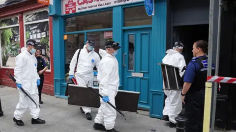 PA Media Forensic officers enter the building where the baby's body was found in Bishop Auckland