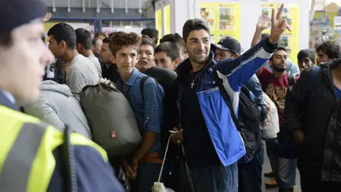 Getty Images Refugees react to the welcome offers of Munich's residents after their arrival at the main train station in Munich