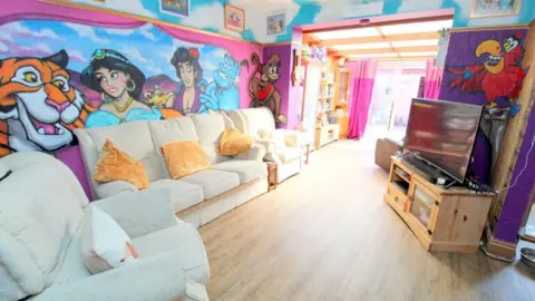 Elwy Estates A living room with characters from Disney's Aladdin painted on its walls.