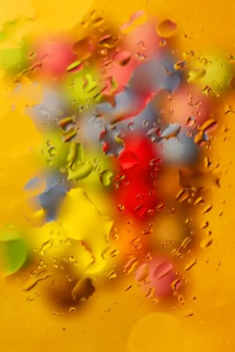 Mike Wright Smarties photographed through glass with water smeared across the surface
