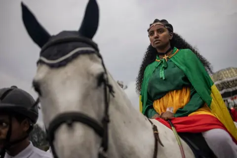 Michele Spatari / AFP A woman dressed in royal attire parades on a horse during celebrations of the Ethiopian Orthodox holiday of Meskel, in Addis Ababa, on September 26, 2024.