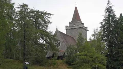 PA Media Church building with red tiled roof sits among trees