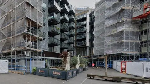 Google Streetview image of the Kino cinema building below an apartment block surrounded with scaffolding