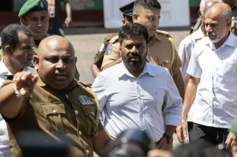 Getty Images Anura Kumara Dissanayake surrounded by men in uniform