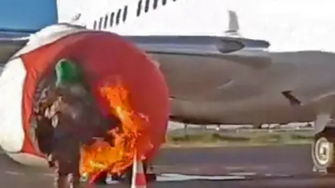 Reuters An armed individual sets fire to a plane at the international airport during an insurgent attack in Bamako, Mali, September 17, 2024, in this screengrab obtained from a social media video