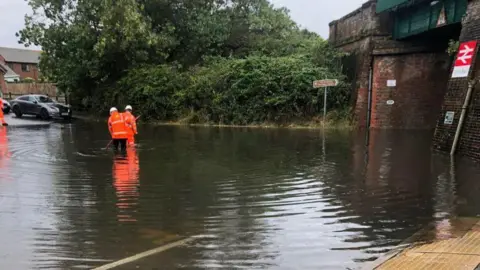 Bailey Moules A flooded road underneath a rail bridge at Cooden Beach station.