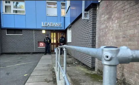 Emma Baugh/BBC Two police officers standing outside the Leabank tower block