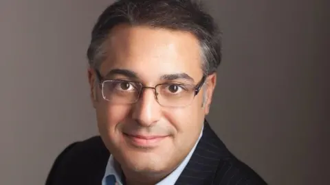 Mr Yaser Jabber seen in an undated professional portrait photograph wearing a smart suit and glasses