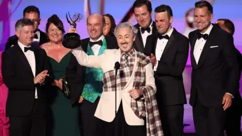 Reuters Alan Cumming, accompanied by cast and crew, receives the Best Competition Program award for "The Traitors" at the 76th Primetime Emmy Awards in Los Angeles, California, U.S., September 15, 2024