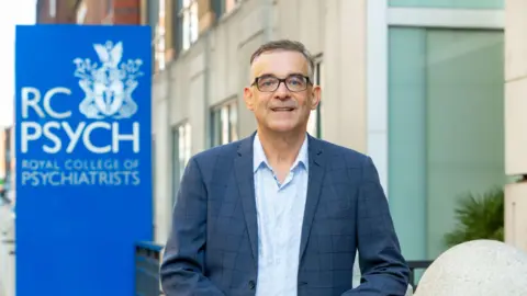 Grainge Photography  Dr Ulrich Müller-Sedgwick stands in front of the office of the Royal College of Psychiatrists.