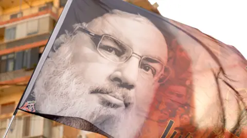 Goktay Koraltan / BBC A flag with a photo late Hezbollah leader Hassan Nasrallah in Beirut