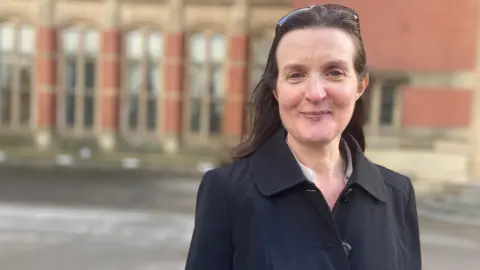 The University of Birmingham's Dominque Moran wearing a black coat with a university building behind her