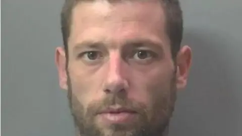 Cambridgeshire Police Man with beard staring at camera