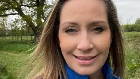 Family photo Close up of Nicola Bulley smiling at the camera with a field and trees in the background