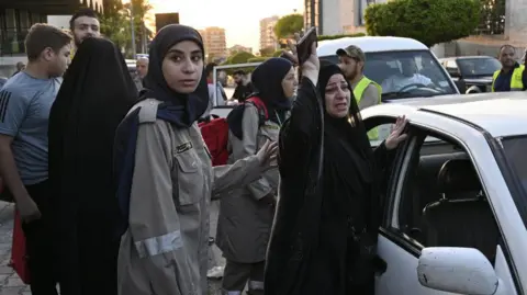 EPA civil defense employee comforts woman who fled southern lebanon, in beirut