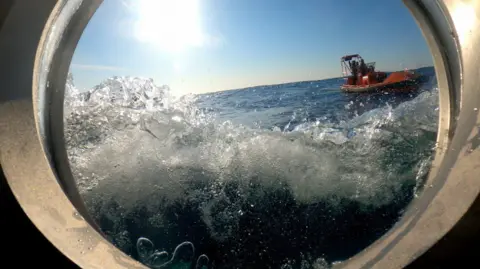 BBC Water hits the window of a submersible in the Atlantic ocean, seen from inside the window