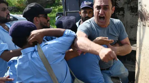 Getty Images An emotional man is restrained