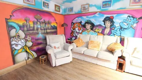 Elwy Estates A living room featuring Aladdin characters painted on the walls