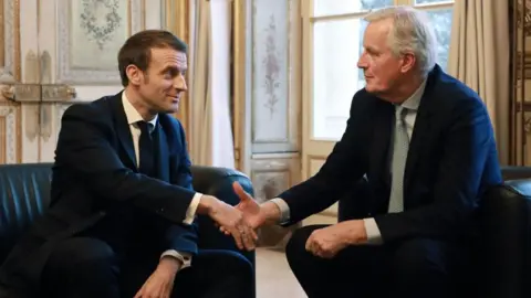 LUDOVIC MARIN/POOL/AFP French president Emmanuel Macron (L) shakes hands with European Commission Chief Negotiator Michel Barnier prior to their meeting at the Elysee palace in Paris, on January 31, 2020