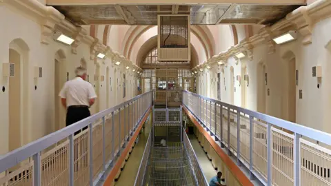 Getty Images A prison officer walks down the C wing at Wandsworth prison in South West London.