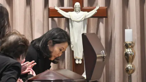 Getty Images Keiko Fujimori, daughter of late Peru's former president Alberto Fujimori, cries next to the coffin during his wake at the Culture Ministry in Lima.