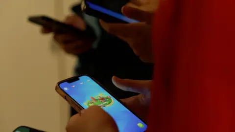 Children play games on their smart phones