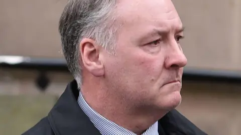 PA Media An image of Ian Paterson with grey hair, wearing a striped shirt