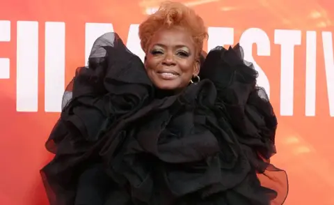 EPA US actor Aunjanue Ellis-Taylor poses on the red carpet for the Nickel Boys gala screening at the BFI London Film Festival - she is smiling and is wearing a black taffeta ruched dress