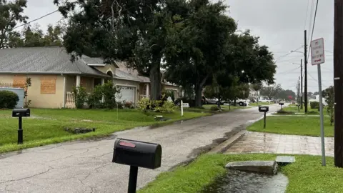 Chynna Perkins Rainwater starts to pool on a Florida street at Hurricane Milton approaches