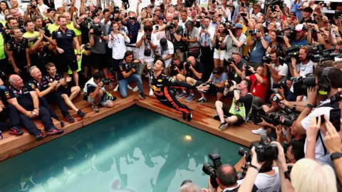 Getty Images Daniel Ricciardo does a swan dive into a pool after his 2018 win in Monaco