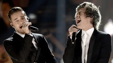 Getty Images Liam Payne and Harry Styles together on stage in smart black jackets both singing