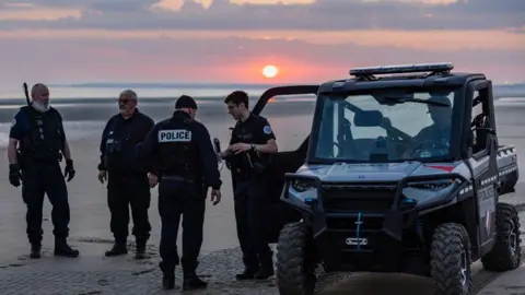 Getty Images Police force on a beach in France, working to stop migrants from crossing in small boats