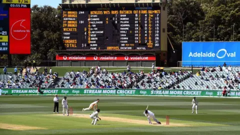 AFP Australia's Pat Cummins (3/L) fells India's Mohammed Shami (2/R) with a bouncer as India is dismissed for only 36 runs on the third day of the first cricket Test match between Australia and India played in Adelaide on December 19, 2020. (