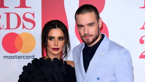 PA Media A woman and man stand next to each other at a red carpet event