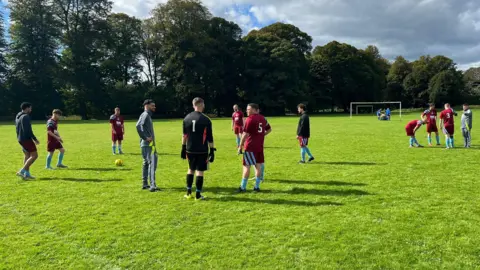 Avenue Hotspur Players from Avenue Hotspur are seen talking amongst themselves on the pitch before the game