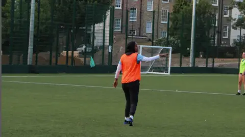 Iqra Ismail Iqra Ismail playing football on a pitch