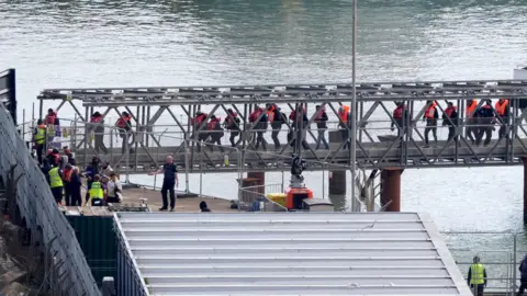 GARETH FULLER/PA WIRE A group of people brought in to Dover, Kent, from a Border Force vessel on Friday