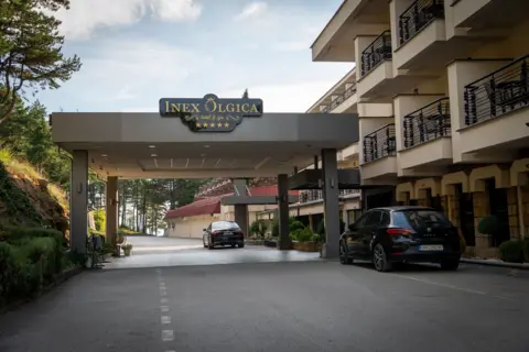 BBC News The entrance to the hotel in North Macedonia where Alex Salmond died, pictured from the road looking up at the building. 