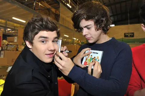 Getty Images Harry Styles signs a CD on Liam's face