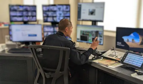 Singapore Prison Service A man sitting behind a desk in the control room at the DRC