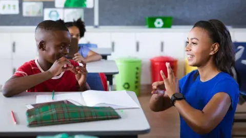 Getty Images A teacher and pupil using British Sign Language in school