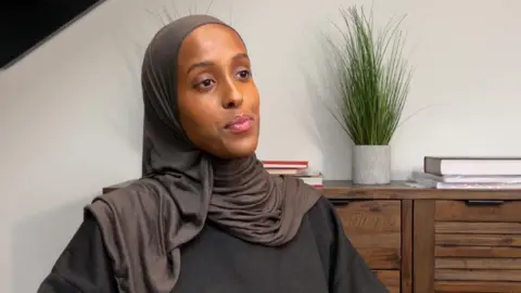 BBC Iqra Ismail, wearing a dark top and a headscarf, speaks to the bbc about the tracksuit bottom issue