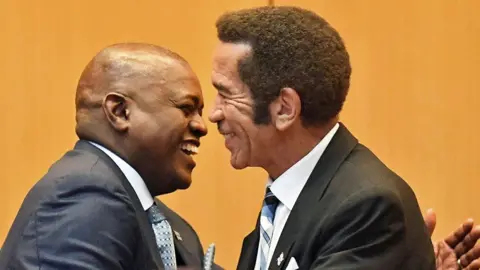 AFP Botswana's President Mokgweetsi Masisi is congratulated by outgoing President Ian Khama (R)  in Gaborone - 1 April 2018