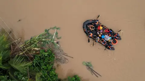 Getty Images An aerial view shows a coast guard rescue boat evacuating residents to safer gounds in Polangui town, Albay province South of Manila on October 23, 2024.